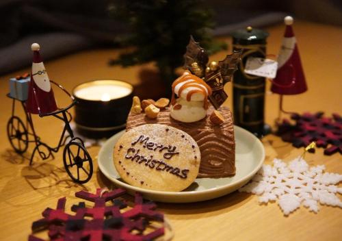 a cake on a plate on a table with christmas decorations at Hotel Graphy Nezu in Tokyo