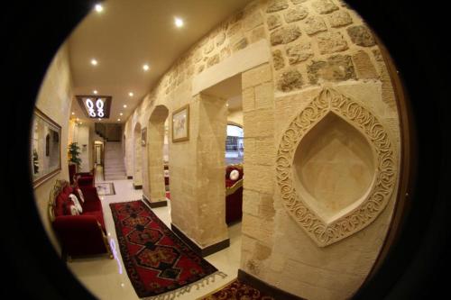a hallway with a large stone wall in a house at Tuğhan Hotel in Mardin