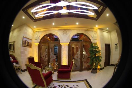 a living room with red chairs and a ceiling at Tuğhan Hotel in Mardin