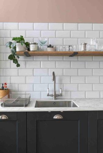 a kitchen with a sink and a white tiled wall at Walpole View - Pet Friendly in Margate
