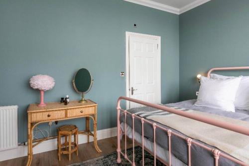 1 dormitorio con cama y mesa con espejo en Walpole View - Pet Friendly, en Margate