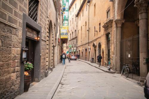 フィレンツェにあるMamo Florence - Borgo San Jacopo Apartmentの通りを歩く人々の入った路地