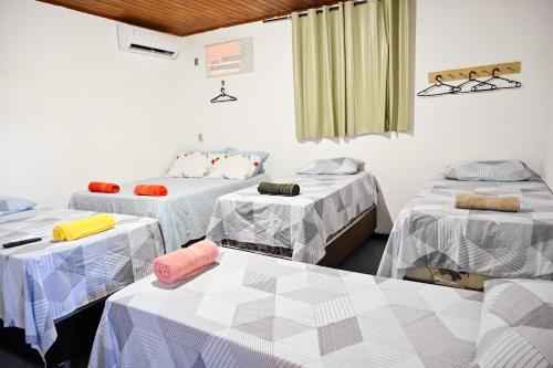 Habitación con 3 camas y mesas. en Hostel mineiros, en Aracaju