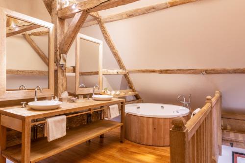 Lémeré的住宿－Hôtel du Château du Rivau，浴室配有2个盥洗盆和1个浴缸。