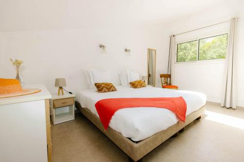 Un dormitorio blanco con una cama grande y una ventana. en Les villas de Bagheera, oasis naturiste, en Linguizzetta
