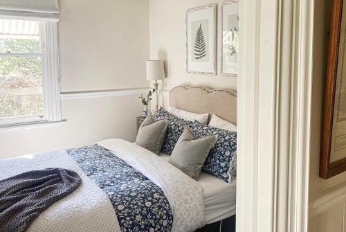 a bedroom with a bed with blue and white pillows at MARIGOLD COTTAGE Charming 1870s central Daylesford cottage in Daylesford
