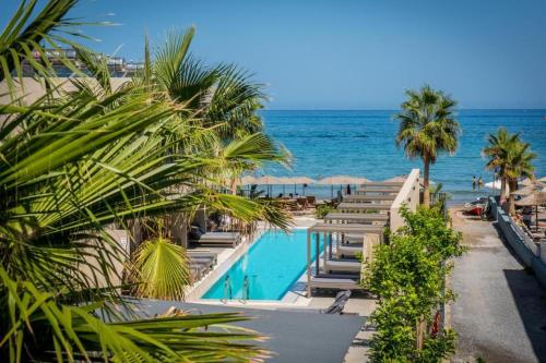 a swimming pool with the ocean in the background at Riviera Boutique Hotel in Stalida