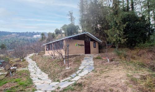 un piccolo edificio in mezzo a un campo di Treebo Trend Daak Bangla Retreat With Mountain View a Shimla
