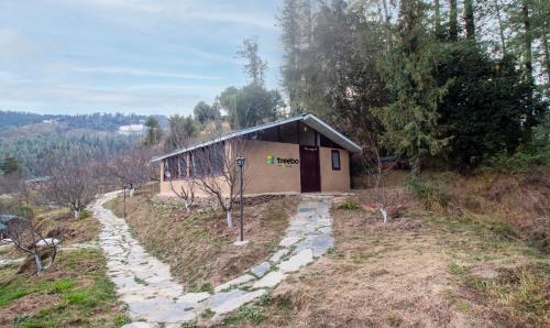 a small building in the middle of a field at Treebo Trend Daak Bangla Retreat With Mountain View in Shimla