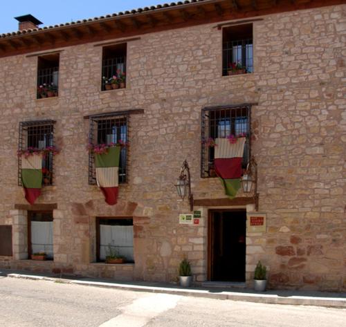 a brick building with potted plants on the windows at Los Cuatro Caños in Sigüenza