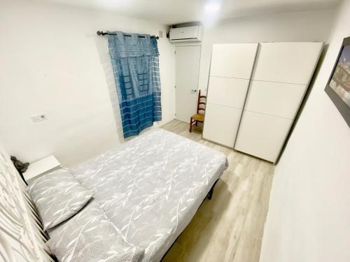a bedroom with a bed and a blue shower curtain at Apartamento Colón in Getafe