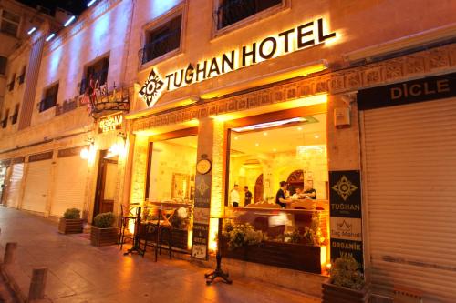 a restaurant with a sign on the front of a building at Tuğhan Hotel in Mardin