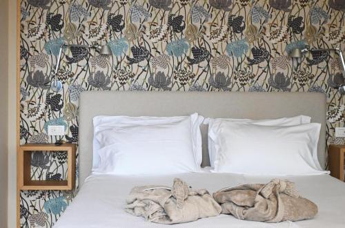 a bed with two pillows and towels on it at Casa Rampolina in Stresa