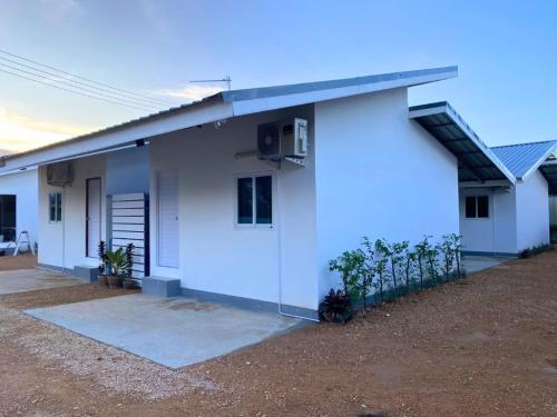 een wit huis met een solarium aan de zijkant bij Cheap N Clear Budget Accommodation in Songkhla