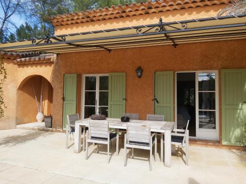 - une table et des chaises sur une terrasse à l'extérieur de la maison dans l'établissement La Bastine, à Lorgues