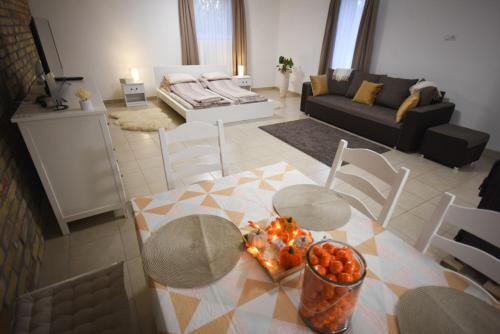 cocina y sala de estar con mesa y sillas en Varázslakos Tanya, en Soltvadkert