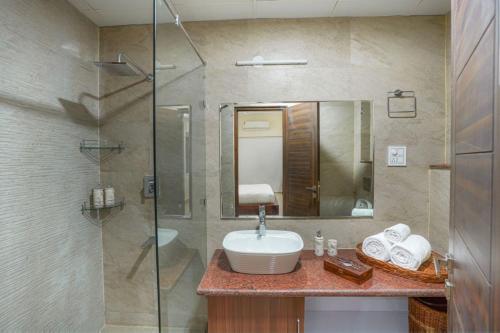 a bathroom with a sink and a glass shower at Golden Healing Journeys Homestay in Rishīkesh