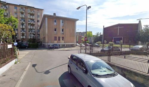 a car parked in a parking lot next to a building at SanSiroFiera Rooms in Milan