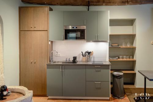 une cuisine avec des placards gris et un comptoir dans l'établissement Le Buffon, à Dijon