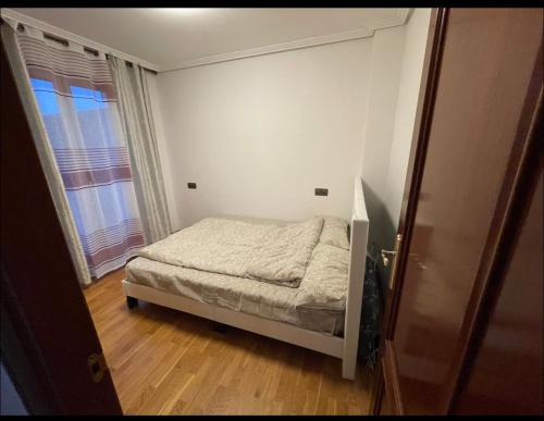 a small bedroom with a bed and a window at Bonito piso con aparcamiento a pie de la calle . in Nájera