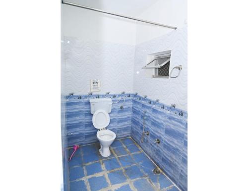 La salle de bains est pourvue de toilettes et de carrelage bleu. dans l'établissement Hotel Panchkund Palace, Pushkar, à Pushkar