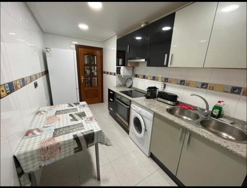 a kitchen with a sink and a washing machine at Bonito piso con aparcamiento a pie de la calle . in Nájera