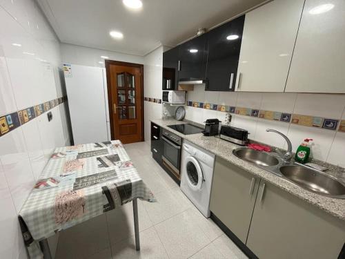 a kitchen with a sink and a washing machine at Bonito piso con aparcamiento a pie de la calle . in Nájera