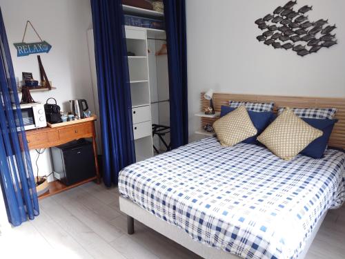 1 dormitorio con 1 cama con manta blanca y azul a cuadros en Cigaléo, Chambre d'hôtes dans le Var, en Carnoules