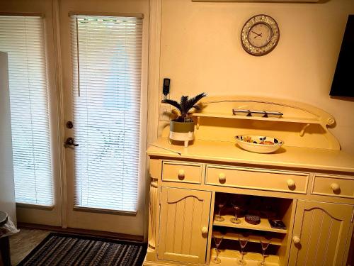 ~ Cozy In-law Apartment Close to Siesta Key ~ في ساراسوتا: مطبخ مع خزانة مع ساعة على الحائط