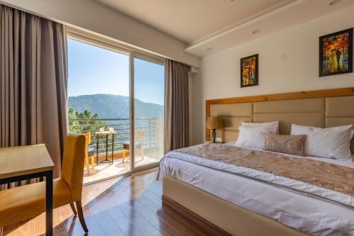 Un dormitorio con una cama y una ventana grande. en Pine Maderas by Embrace, en Kasauli