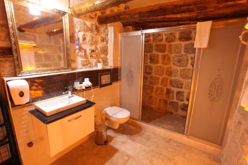 a bathroom with a sink and a toilet and a shower at Tuğhan Hotel in Mardin