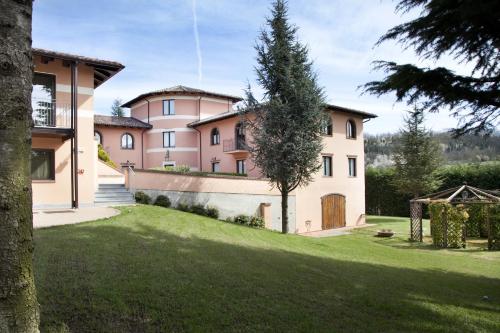a large house with a grass yard in front of it at Villa Castelletto in Castelletto Molina