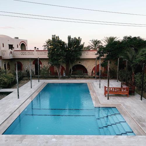 a swimming pool with a bench in front of a building at Zad El Mosafer Guest House in Tunis