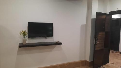 a flat screen tv on a white wall at LOKAL Rooms x Multan (City Center) in Multan