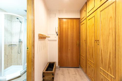 a bathroom with a shower and a wooden door at Apartamento Nature in Sierra Nevada
