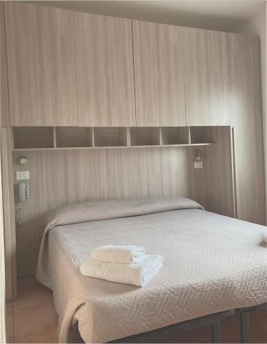 a bedroom with a bed with two towels on it at Hotel Villa Itala in Rimini