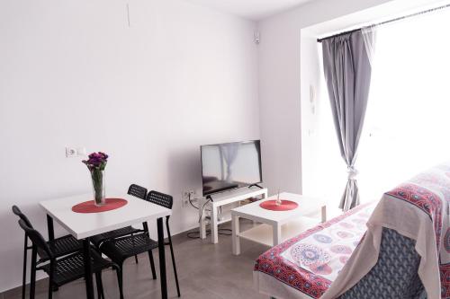 Habitación con cama, mesa y TV. en Casa completa triplex & parking by Gades Gestión, en Cádiz