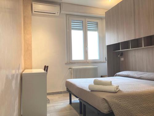 una camera da letto con un letto e asciugamani di Hotel Villa Itala a Rimini