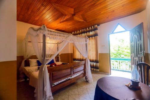 ein Schlafzimmer mit einem Himmelbett und einem Fenster in der Unterkunft The Green Heaven Resort in Sigiriya