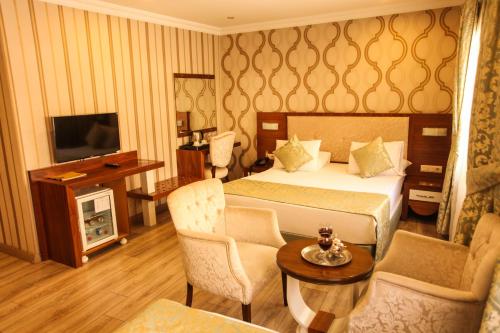a hotel room with a bed and a television at Tuğhan Hotel in Mardin