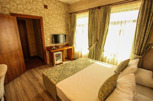 a hotel room with a bed and a window at Tuğhan Hotel in Mardin