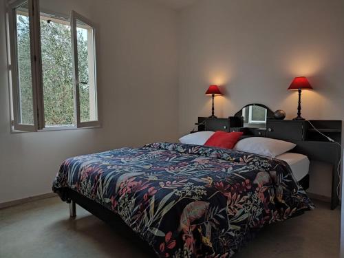 ein Schlafzimmer mit einem Bett mit einer bunten Decke und einem Fenster in der Unterkunft Maison Au P'tit Bonheur in Argenton-sur-Creuse