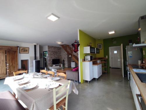 a kitchen and a dining room with a table and a kitchen and a living room at Maison Au P'tit Bonheur in Argenton-sur-Creuse