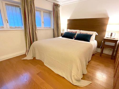 une chambre avec un grand lit blanc avec des oreillers bleus dans l'établissement L'appartement Pierre Charron, à Paris