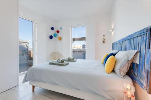 a white bedroom with a large bed and a window at CASA LIMA - State of the art villa with views and pool in Ferragudo in Ferragudo
