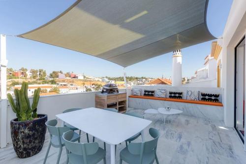 a balcony with tables and chairs and a view of the city at CASA LIMA - State of the art villa with views and pool in Ferragudo in Ferragudo