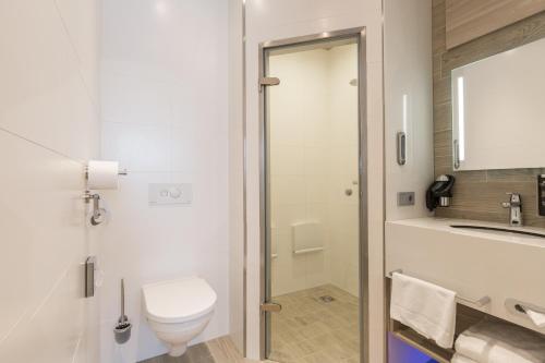 a bathroom with a toilet and a sink at Ramada The Hague Scheveningen in Scheveningen