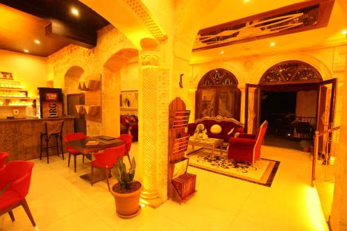 a living room with red chairs and a fireplace at Tuğhan Hotel in Mardin