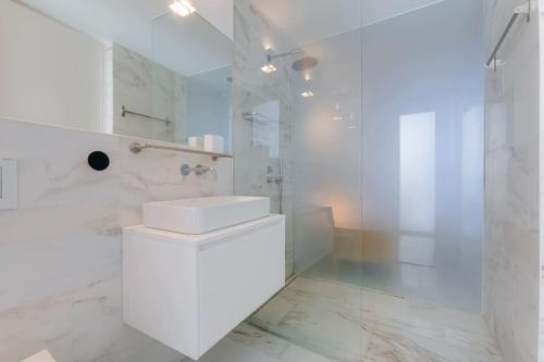 a white bathroom with a toilet and a shower at CASA LIMA - State of the art villa with views and pool in Ferragudo in Ferragudo