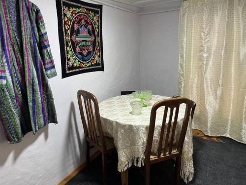 een eettafel met 2 stoelen en een foto bij HOSTEL TASMIN MEXR in Samarkand